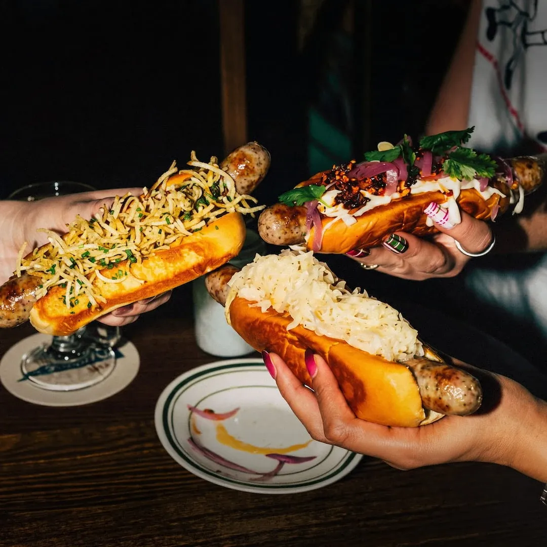 Gourmet sausages served in toasted bread with toppings.