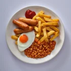 Sausages, chips, fried egg and baked beans