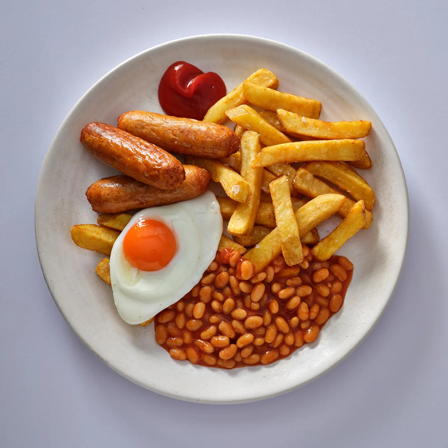 Sausages, chips, fried egg and baked beans