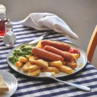 Sausages served with chips, peas and peas